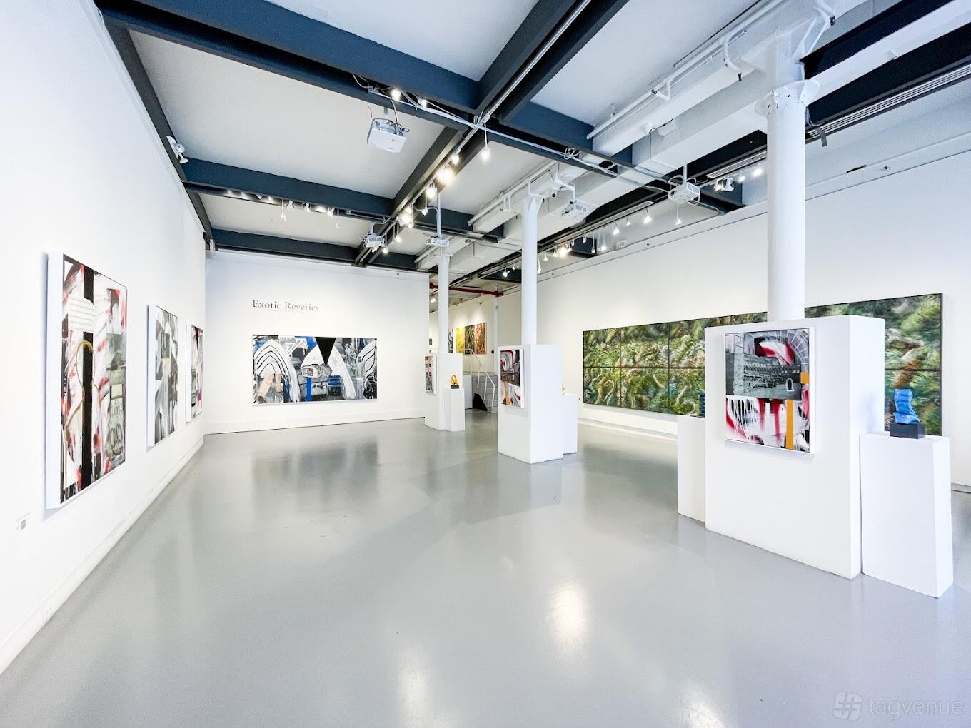 A gallery with white walls, polished gray floors, contemporary paintings, and large support columns at White Space Chelsea.
