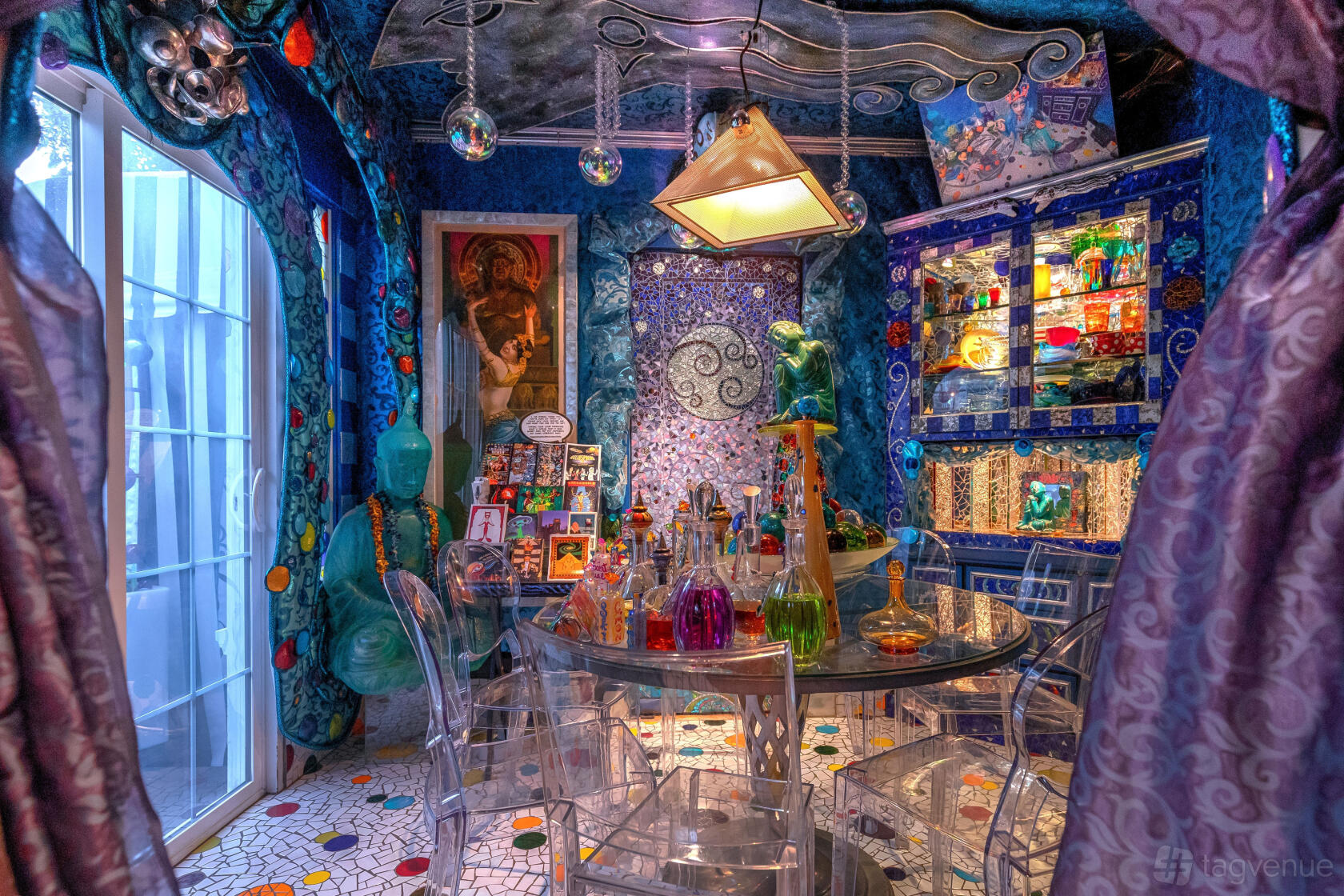 An event space with mosaic tile floors, colorful glass bottles, and eclectic artwork at The Gregangelo Museum.