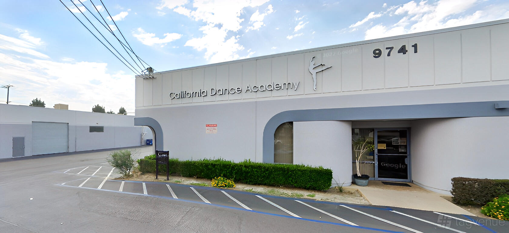 A dance studio with a curved entrance, large windows, and prominent signage at California Dance Academy.