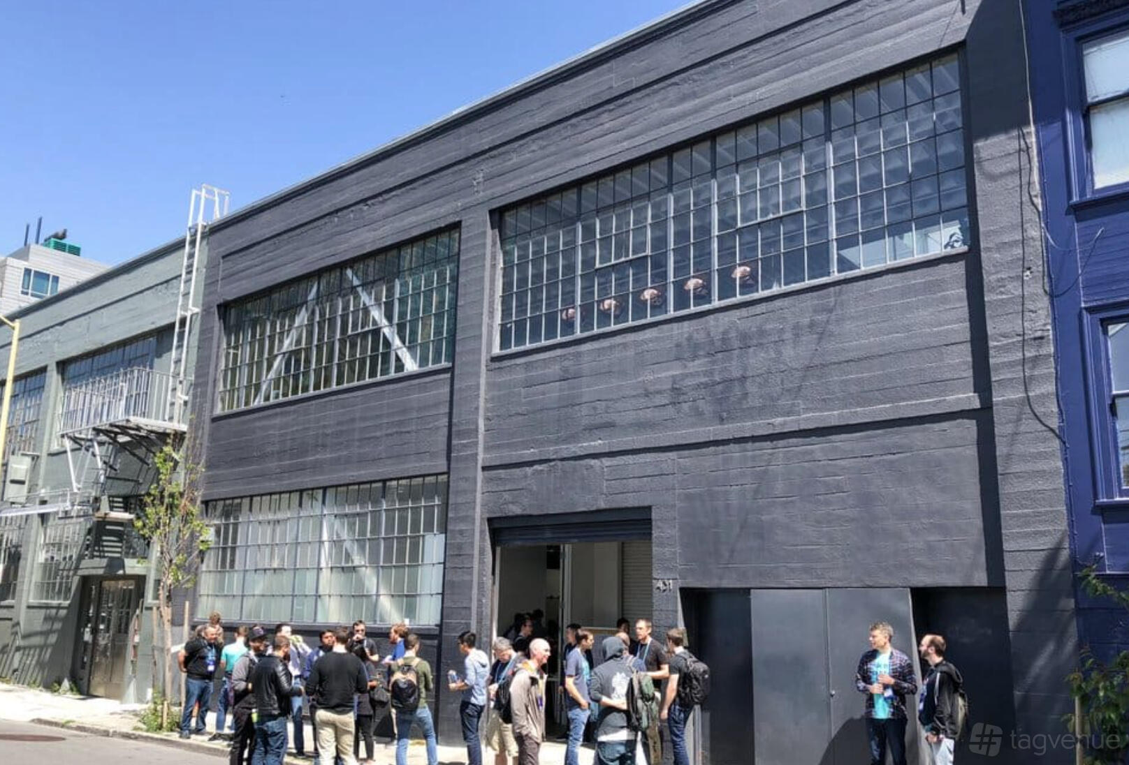A warehouse with large industrial windows and a gray facade at Alloy Collective.