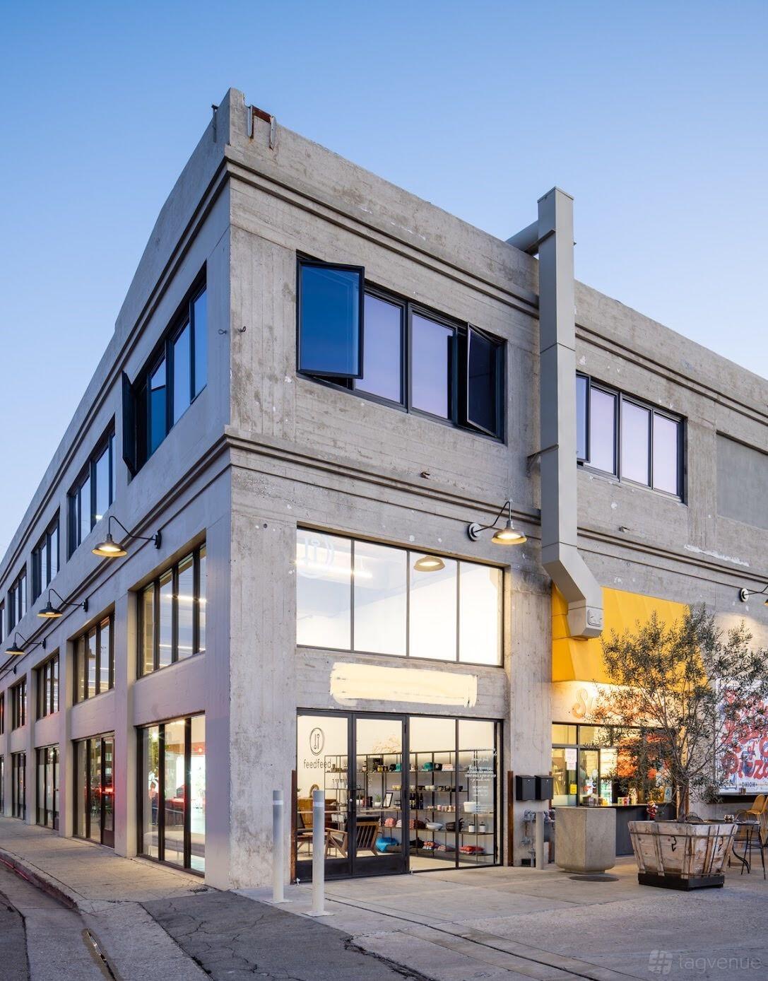 A versatile event space with large grid windows and a concrete exterior at Feedfeed.