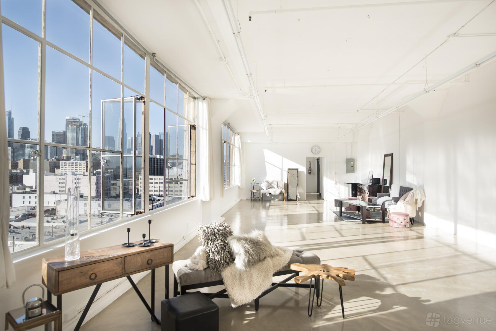 An event venue with floor-to-ceiling windows, polished concrete floors, and city skyline views at Skyline SUITE.