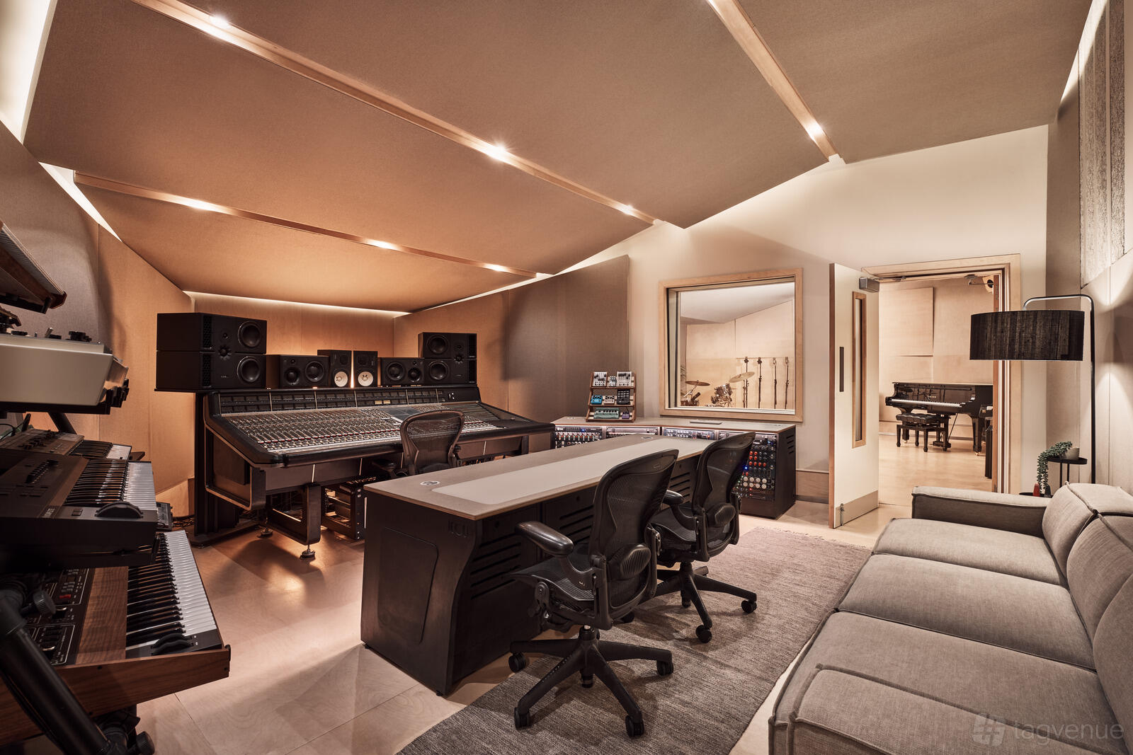 A recording studio with an analog mixing console, studio monitors, and acoustic paneling at Ten87 Studios.