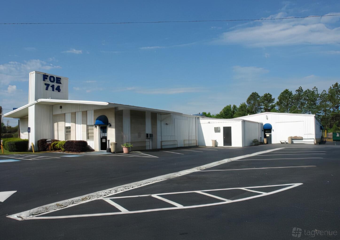 A standalone pub with white exterior walls, flat roofs, and blue awnings at Sweet Treat Productions.