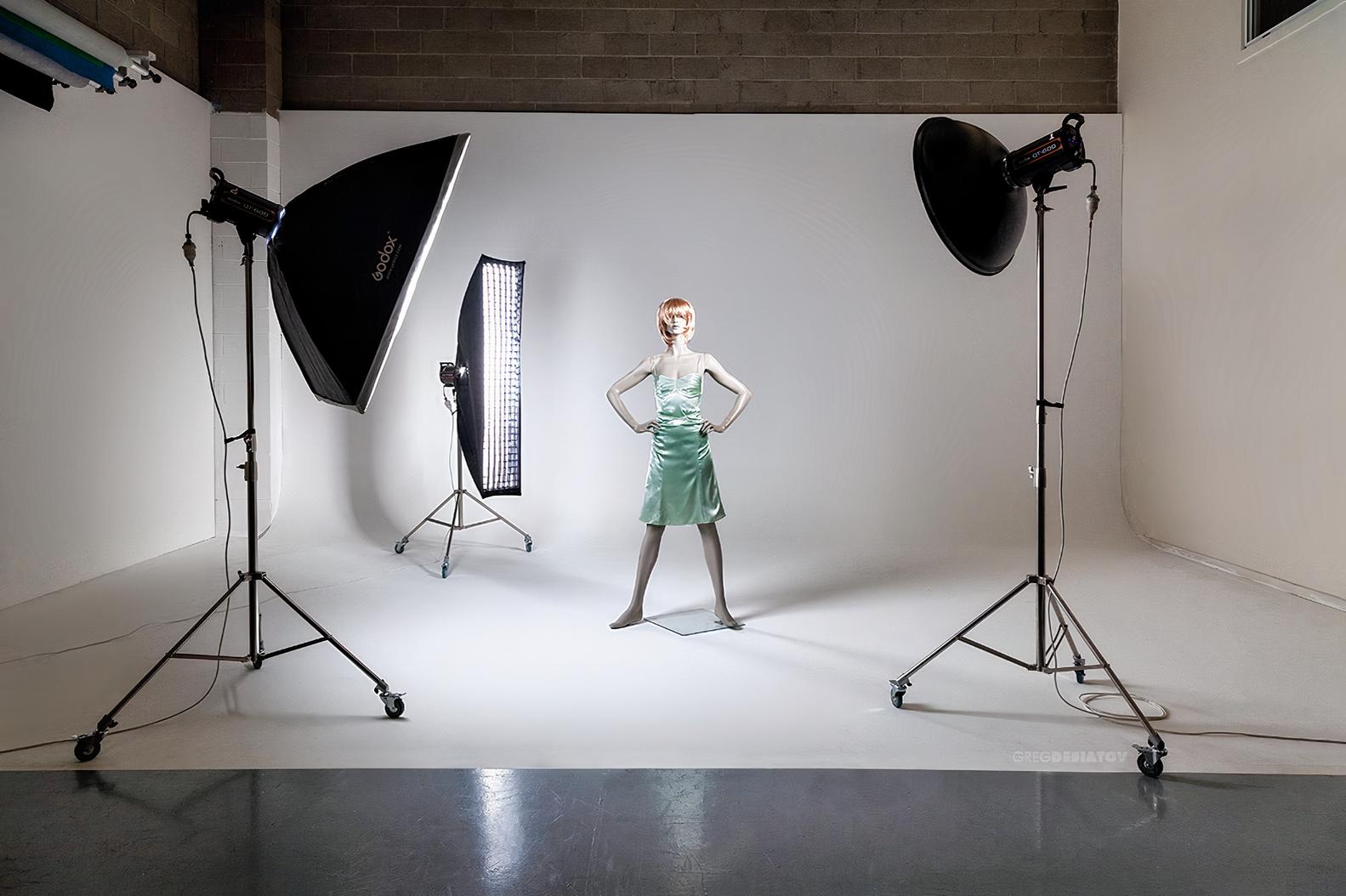 A photo studio with white cyclorama walls, softbox lighting, and a mannequin at Picture Perfect Photo Studio.