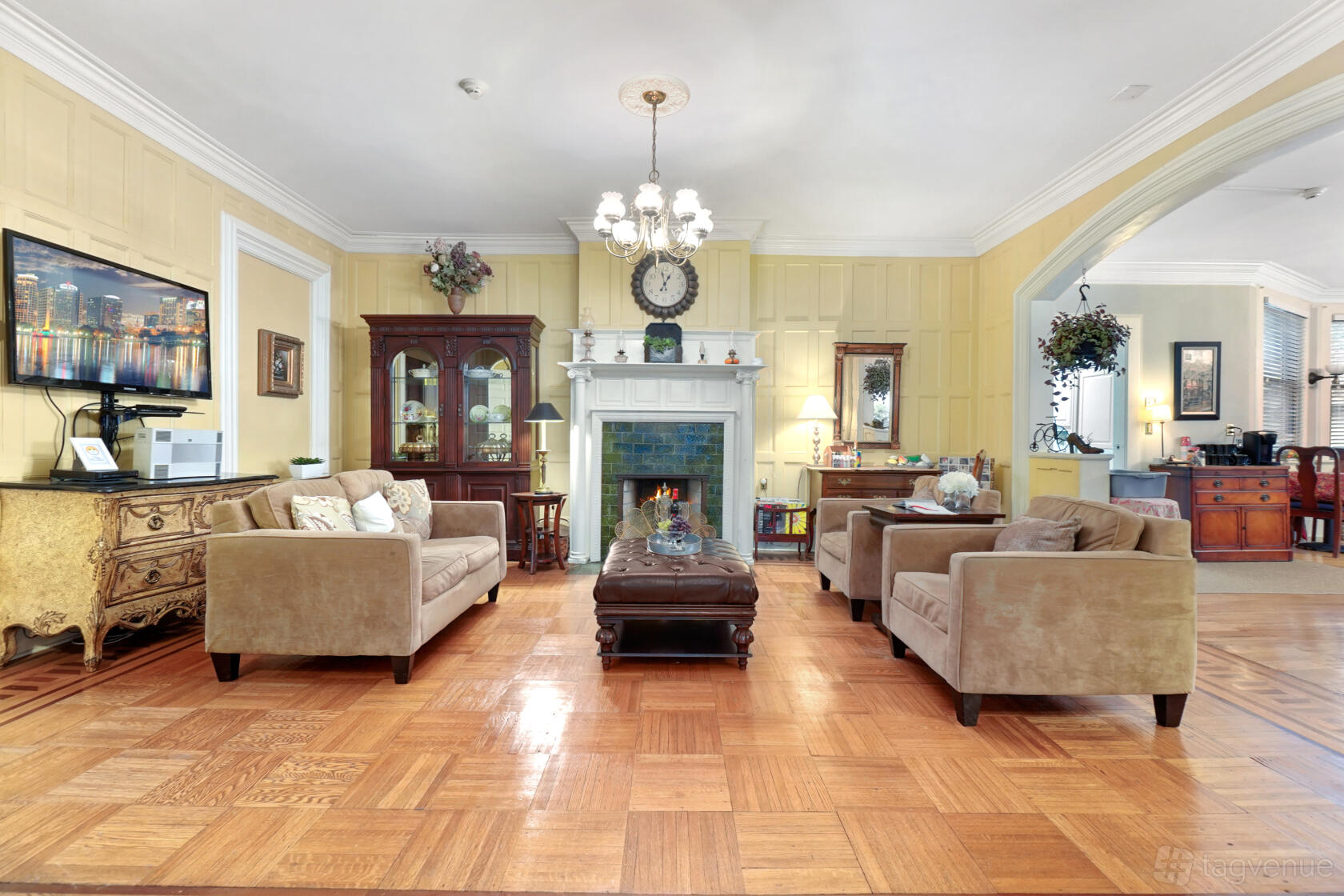 An event venue with wood parquet floors, a fireplace, large windows, and plush seating at The DeBary Inn.