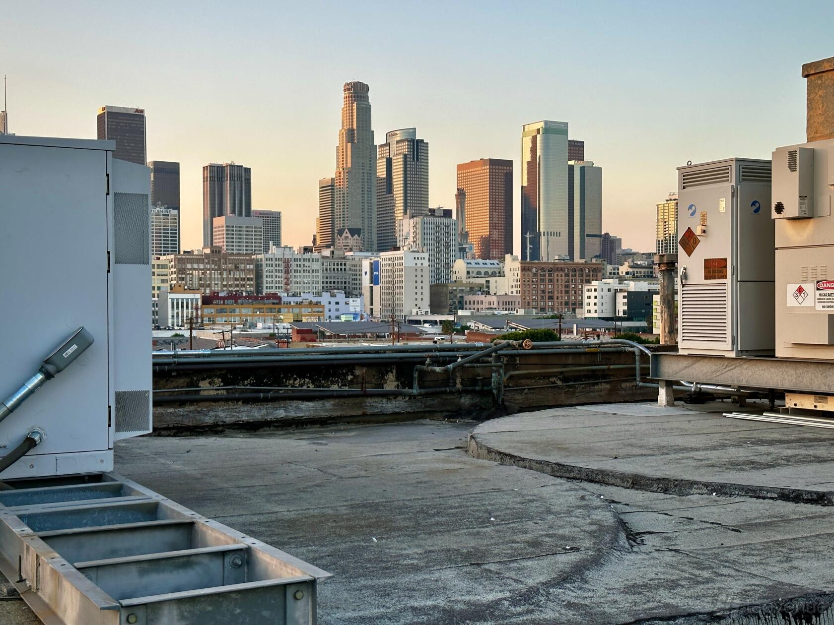 An open air rooftop venue with a city skyline view and industrial equipment at Crow’s Nest - Downtown LA.
