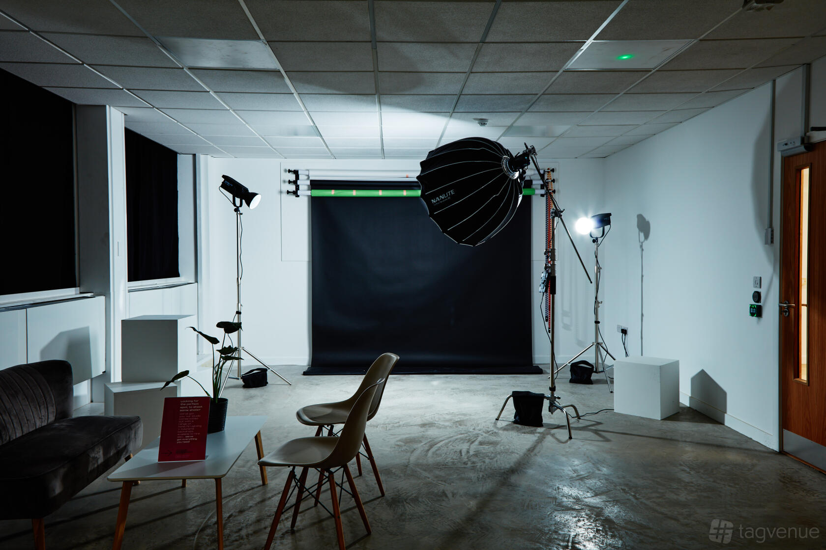 A coworking space with a professional photography setup, backdrop, softbox lights, and seating at MAKE IT Barking.
