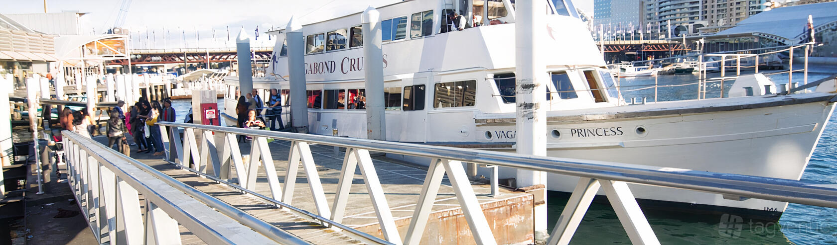 A white boat docked at a marina with upper and lower decks at M.V. Vagabond Princess.