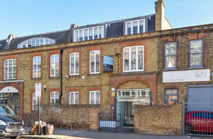 A versatile event space in a brick building with large windows and a glass entrance at Associated Studios.