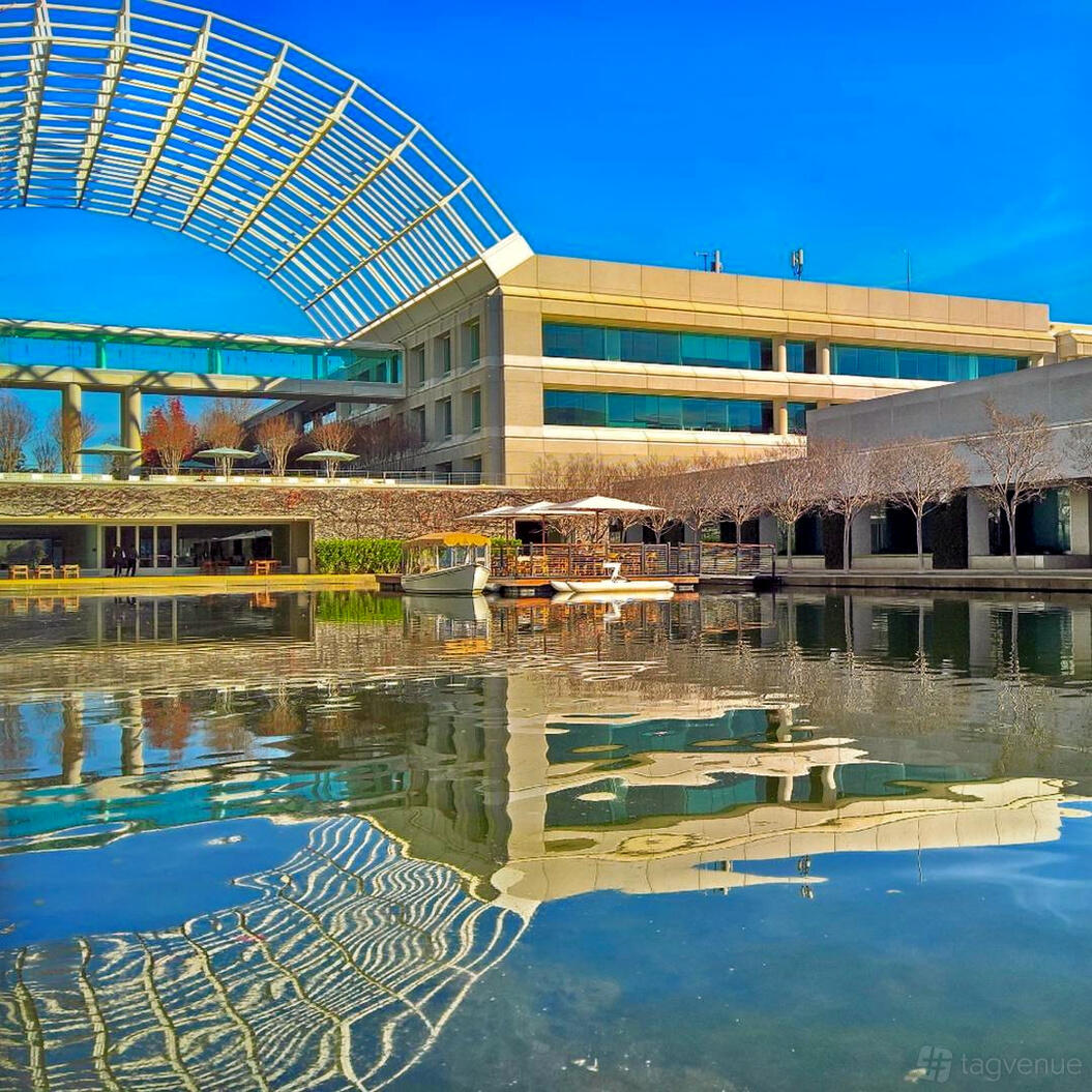 A conference centre with waterside outdoor seating and a modern glass canopy at Roundhouse Market & Conference Center.