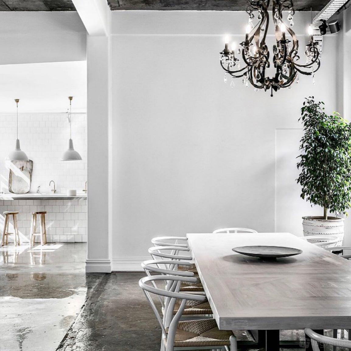 A bright kitchen with white tile backsplash, pendant lighting, and wooden stools at La Porte Space.