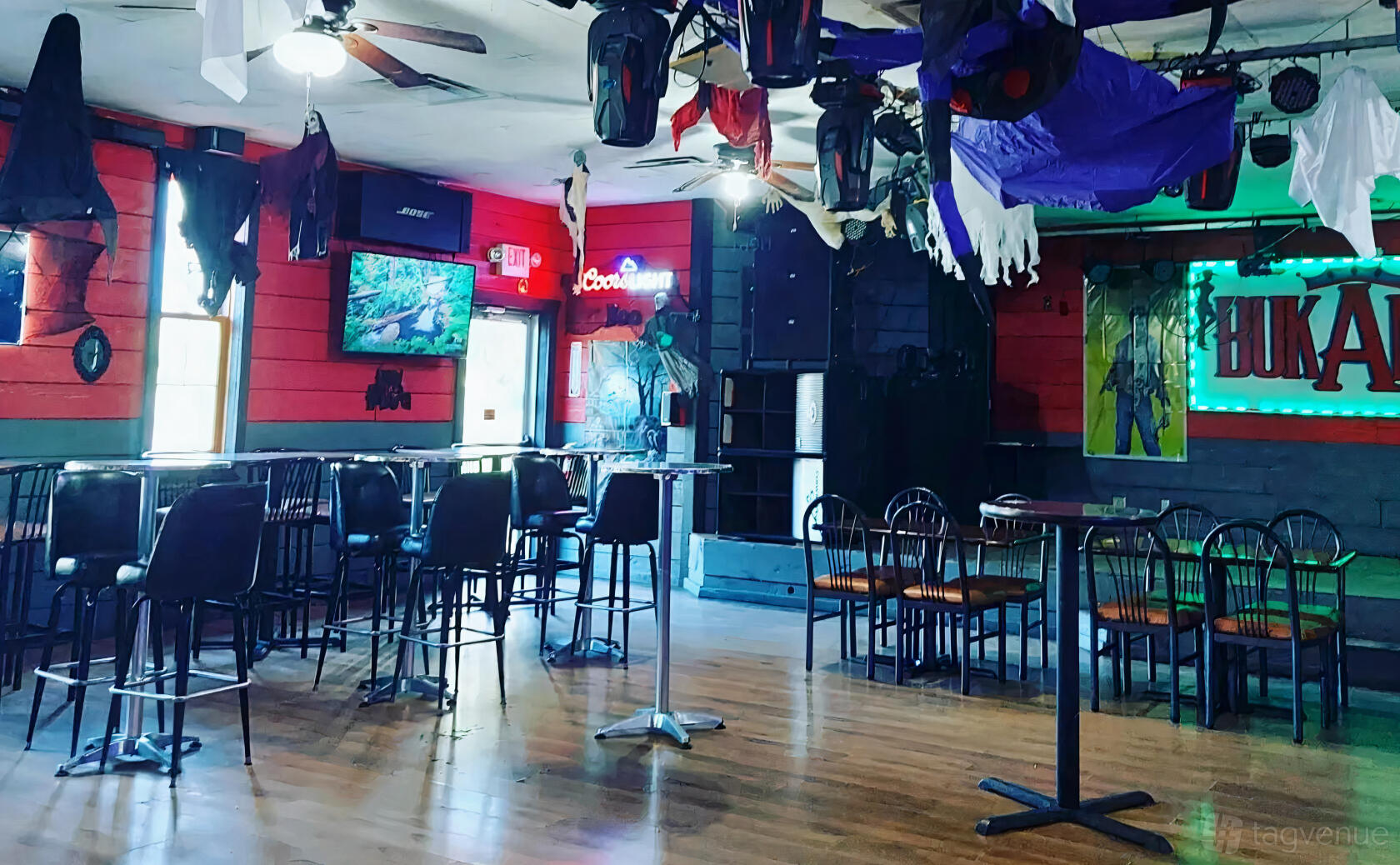A restaurant with wooden floors, mixed table seating, and Halloween decorations at TEKILAS MEXICAN GRILL & BUKANAS BAR.