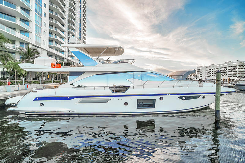 A yacht with large windows, sleek white exterior, and upper deck docked at Jerico Yacht Charters.