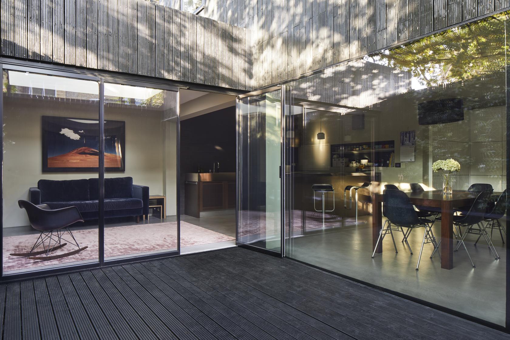 A photo and film studio with floor-to-ceiling glass doors, open-plan seating, and a modern dining area at Eds Shed.
