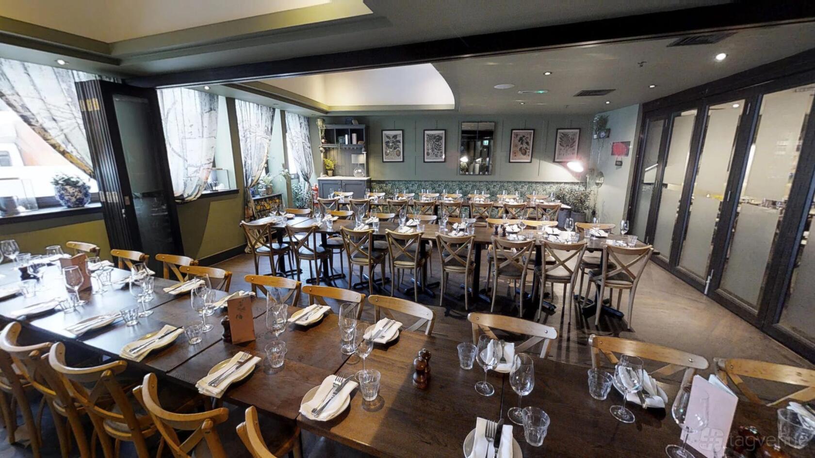An event space in a restaurant with long banquet tables, wooden chairs, and natural light at Brasserie Blanc Southbank.