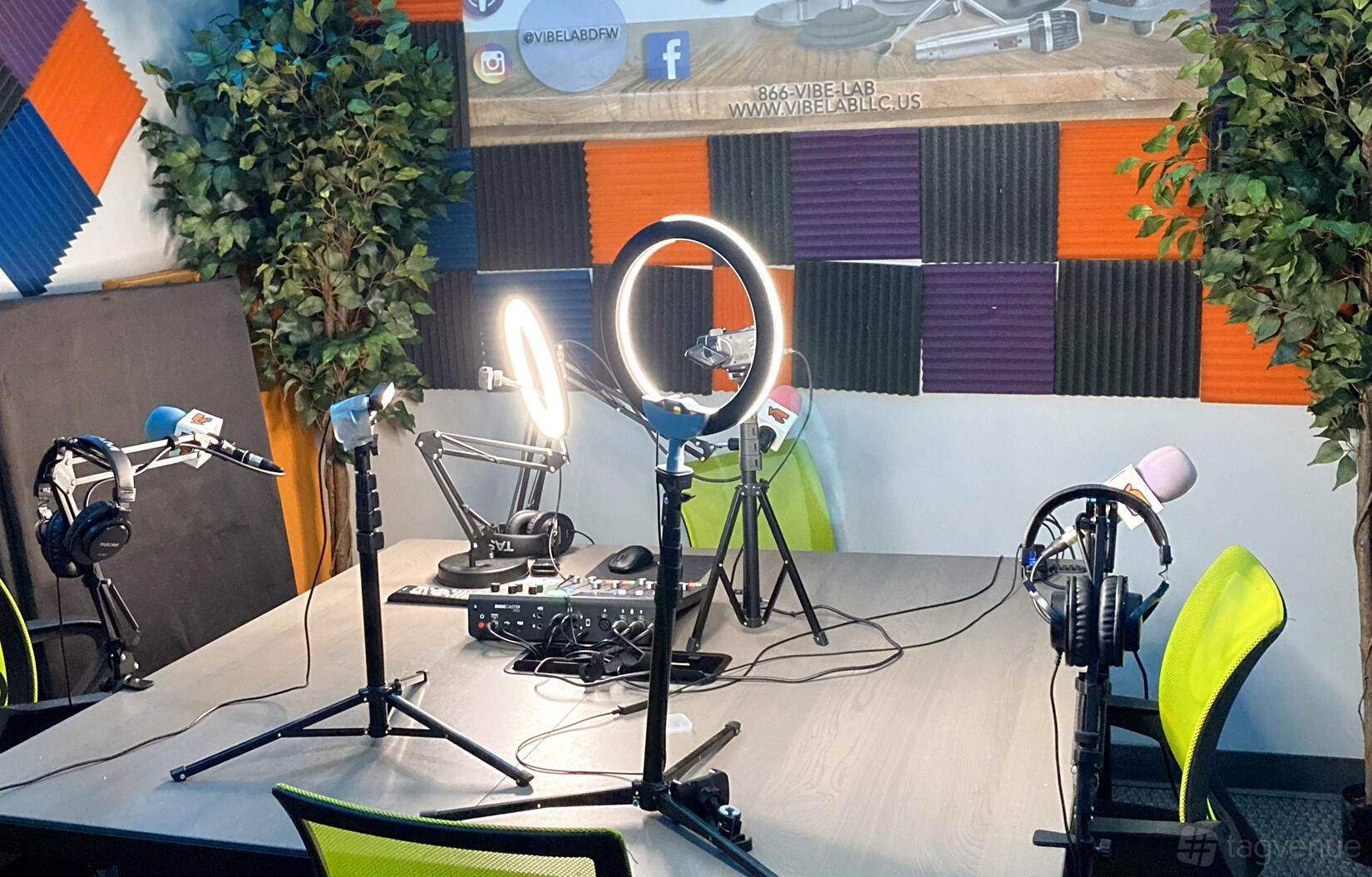 A recording studio with ring lights, microphones, and colorful acoustic panels at Vibe Lab LLC.
