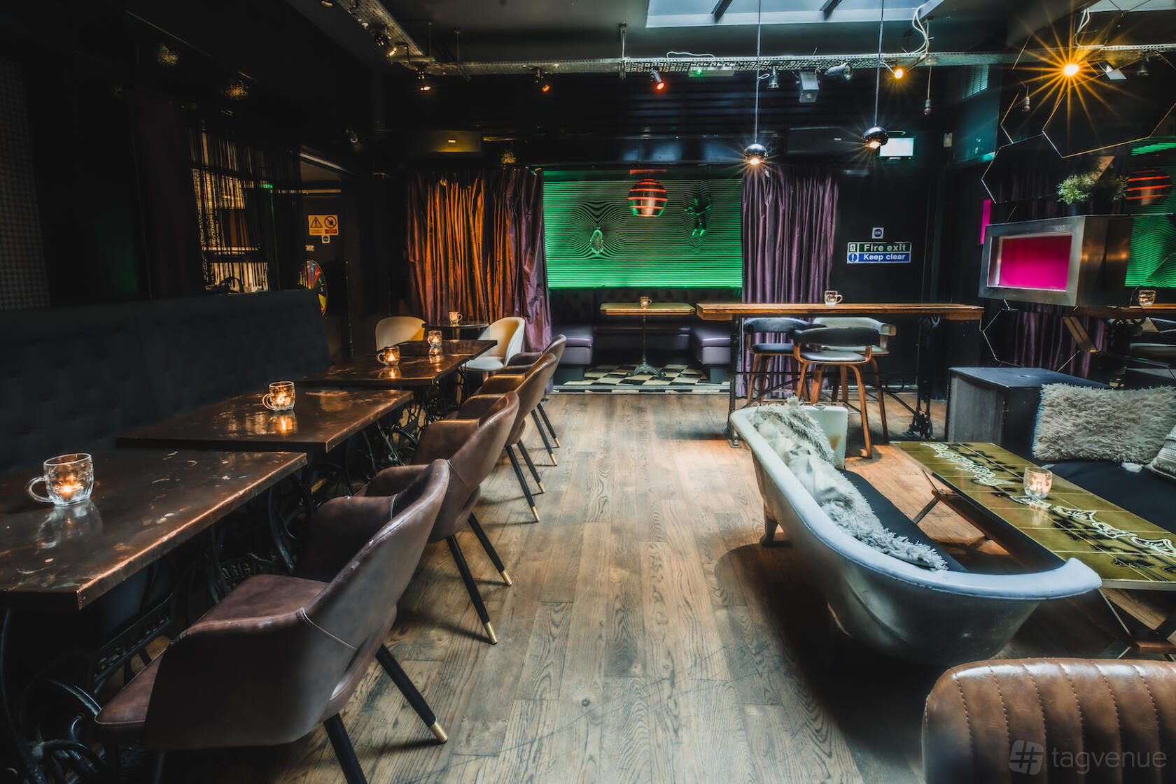 A cocktail bar lounge with eclectic seating, dim lighting, and a bathtub centerpiece at Callooh Callay Shoreditch.
