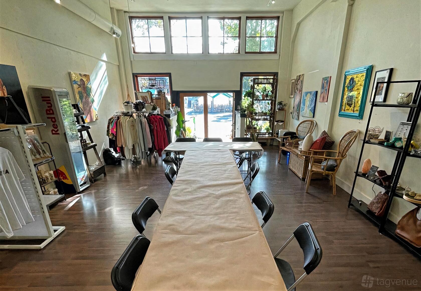 An event venue with high ceilings, large windows, folding chairs around long tables, and eclectic decor at Made Space.