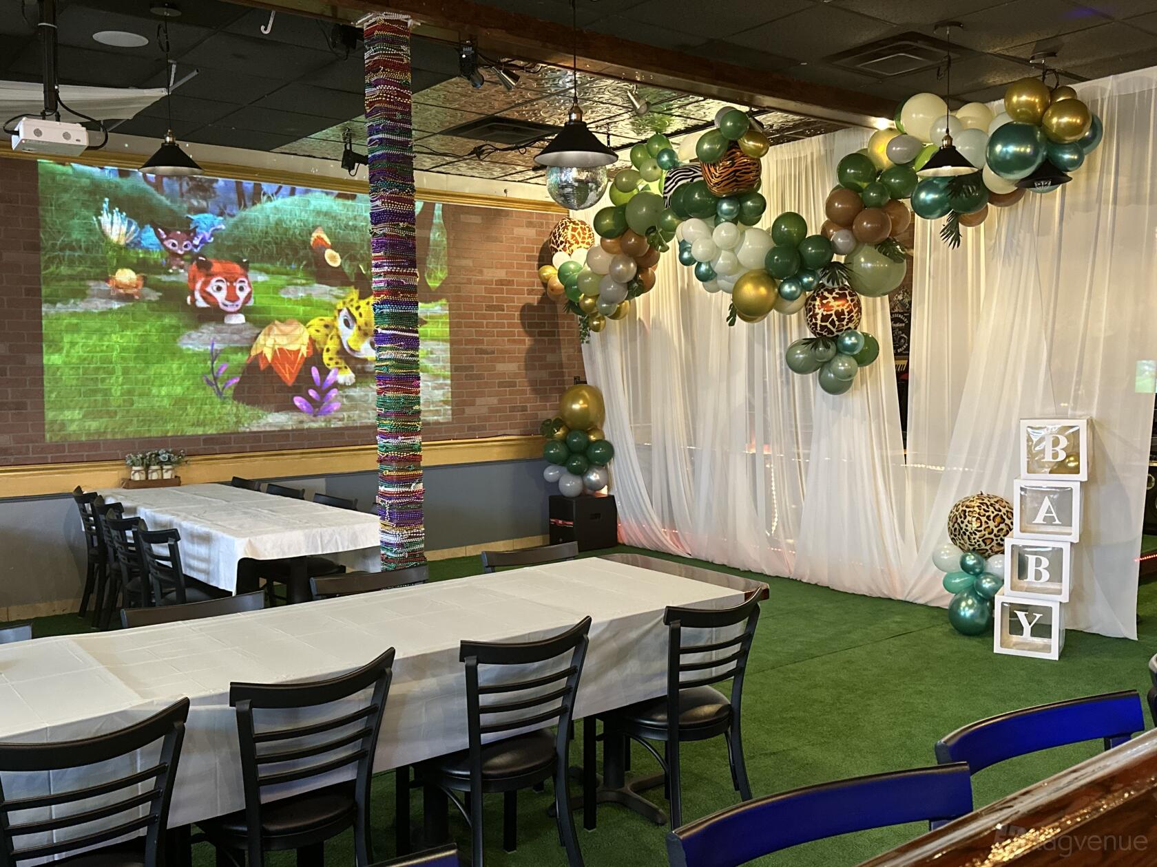 A restaurant with white draped decor, balloon garland, and rectangular tables with black chairs at Si Lom Bar Asian Cuisine.