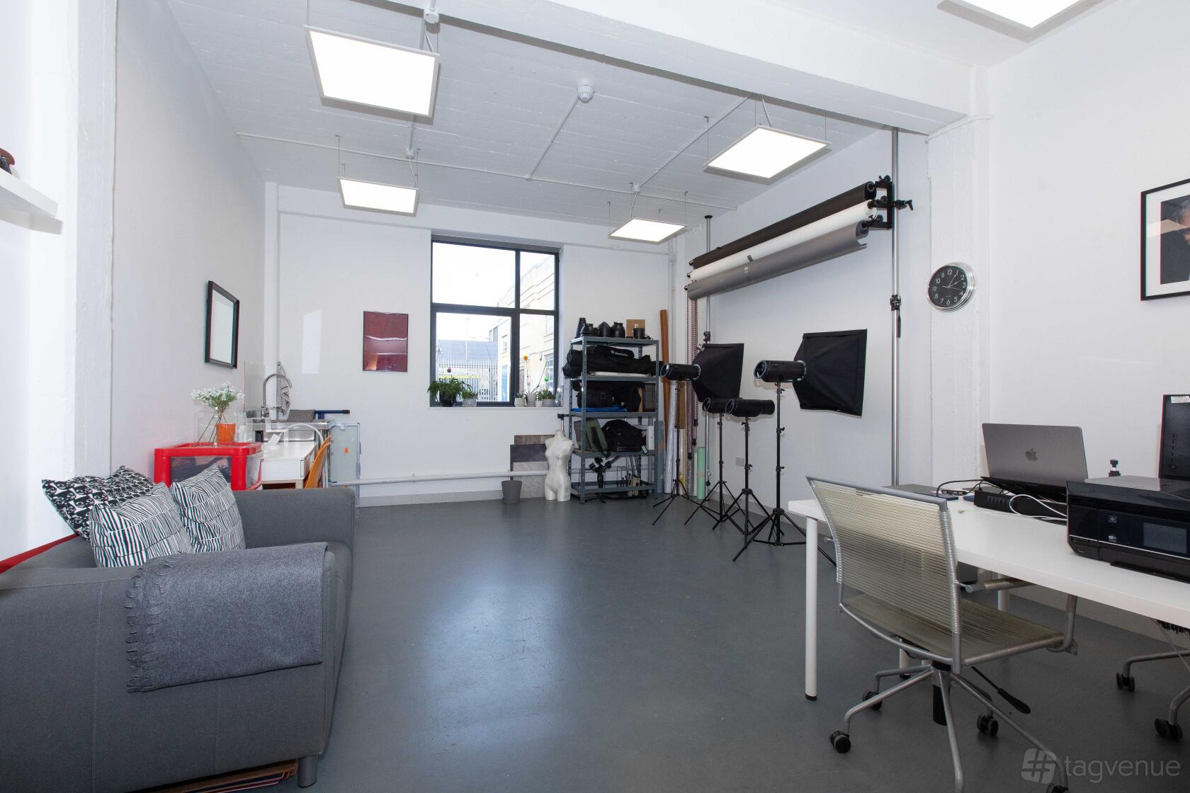 A photo studio with seamless backdrops, softbox lighting, and a large window at Delta House Studio.