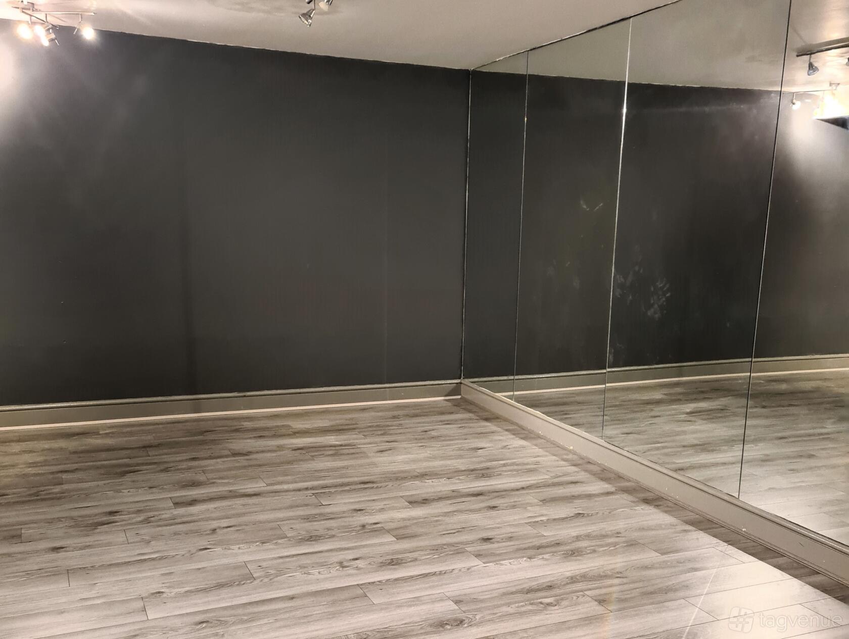 A rehearsal studio with floor-to-ceiling mirrors and light wood flooring at BGM Studios.