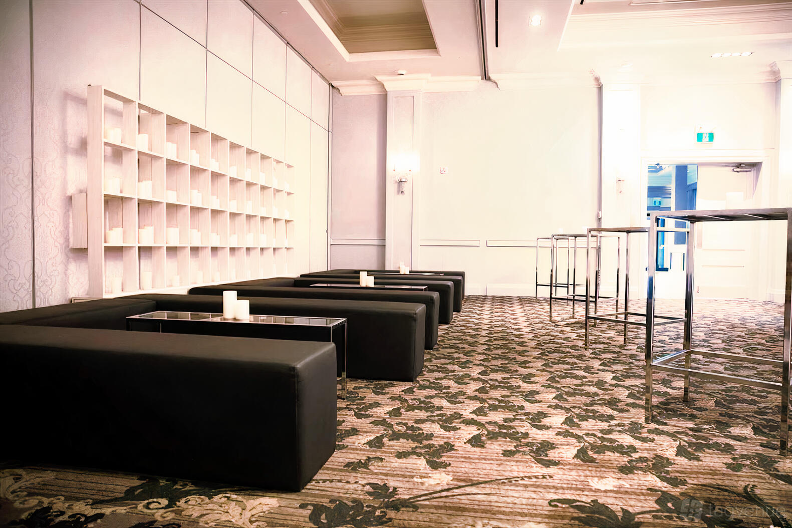 An event space with black lounge sofas, candlelit low tables, and open shelving at Parkview Manor.