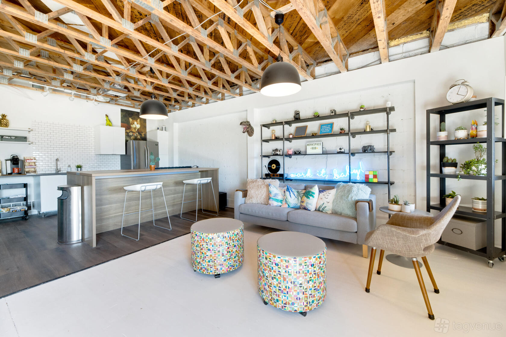 A coworking space with exposed wooden beams, open shelving, a lounge area, and a kitchenette at Workspace 808.