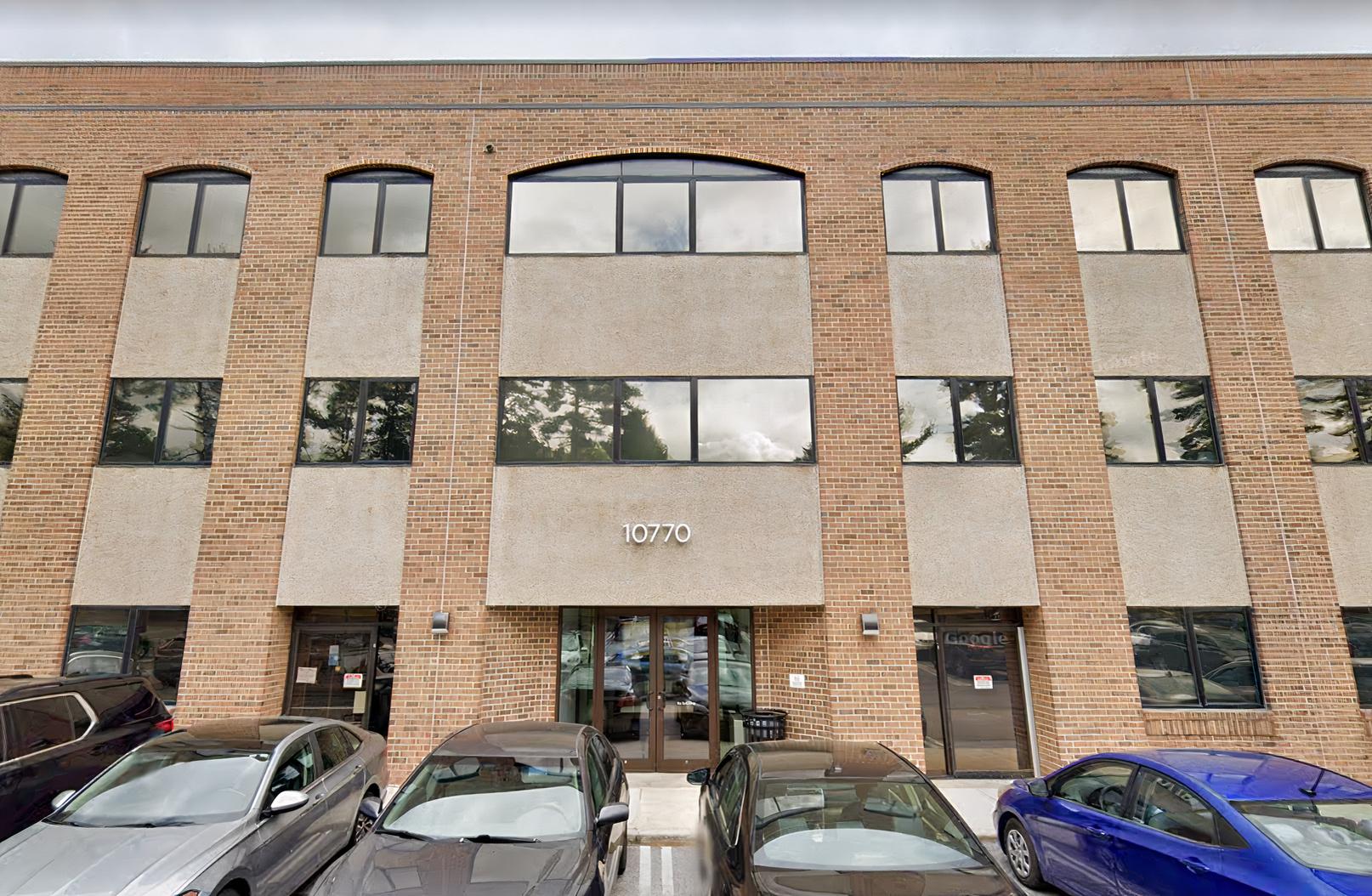 A meeting centre with a brick facade, large windows, and a glass entrance at Perfect Office Solutions - Silver Spring.