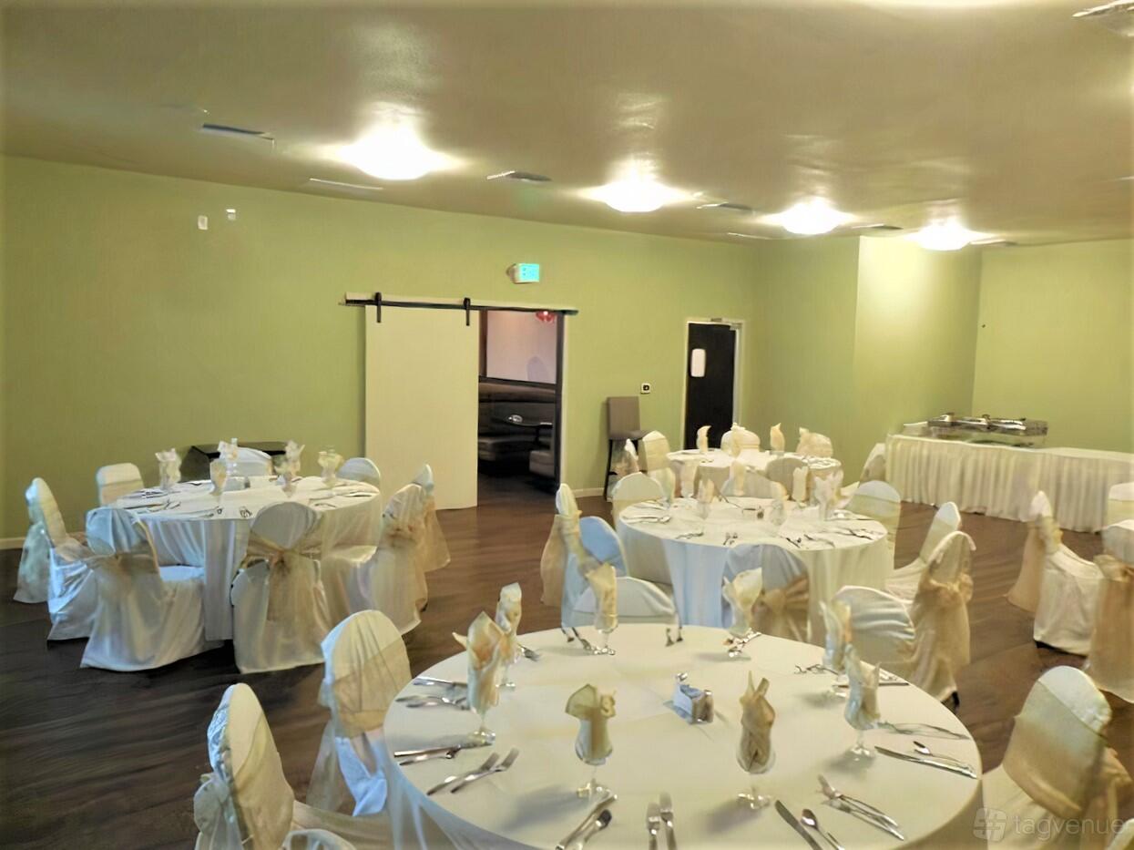 An event space with round tables covered in white linens and banquet chairs at JP's Family Restaurant.