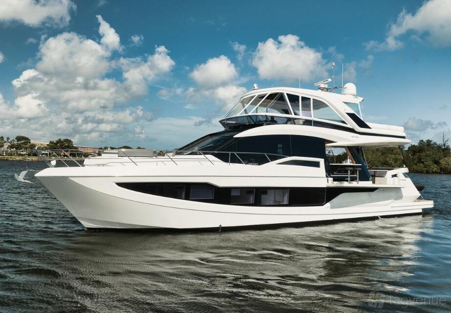 A white luxury yacht with multiple decks and large windows cruising on the water at Lots Of Yachts/Lots Of Spots South Florida.