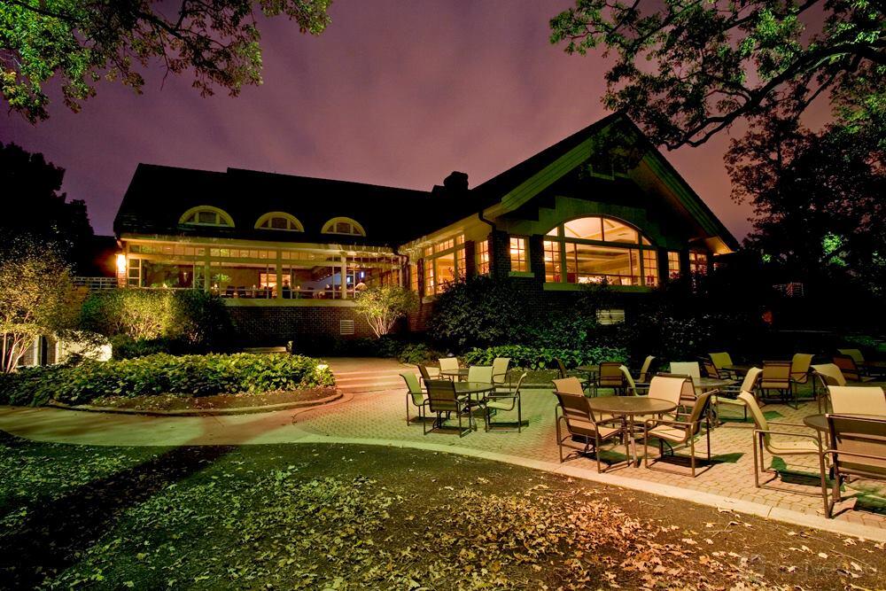 An event space with outdoor patio seating, round tables, and large windows at Stonebridge Country Club.