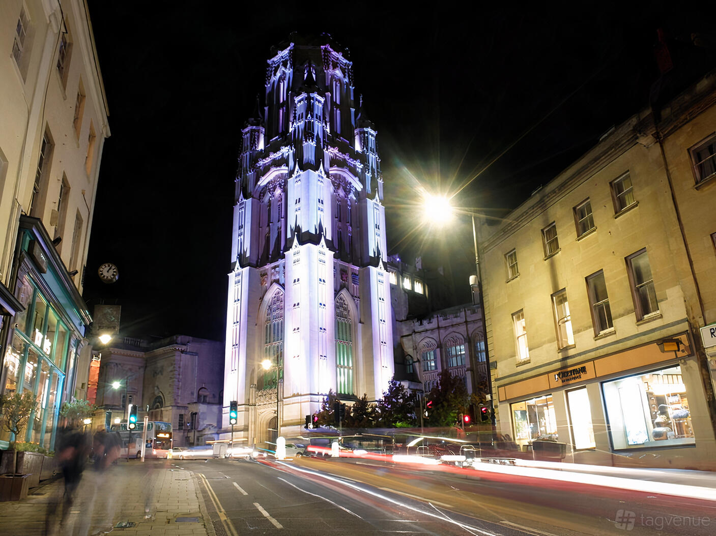 A historic building with a tall illuminated Gothic tower and stone façade at Wills Memorial Building.