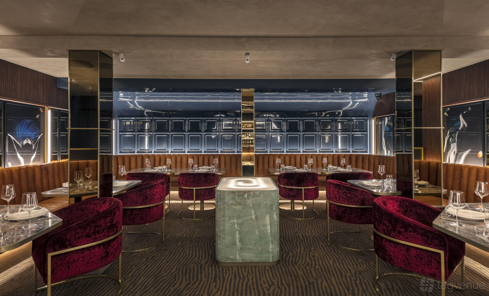 A cafe with velvet chairs, marble tables, wood paneling, and mirrored walls at The aVenue.