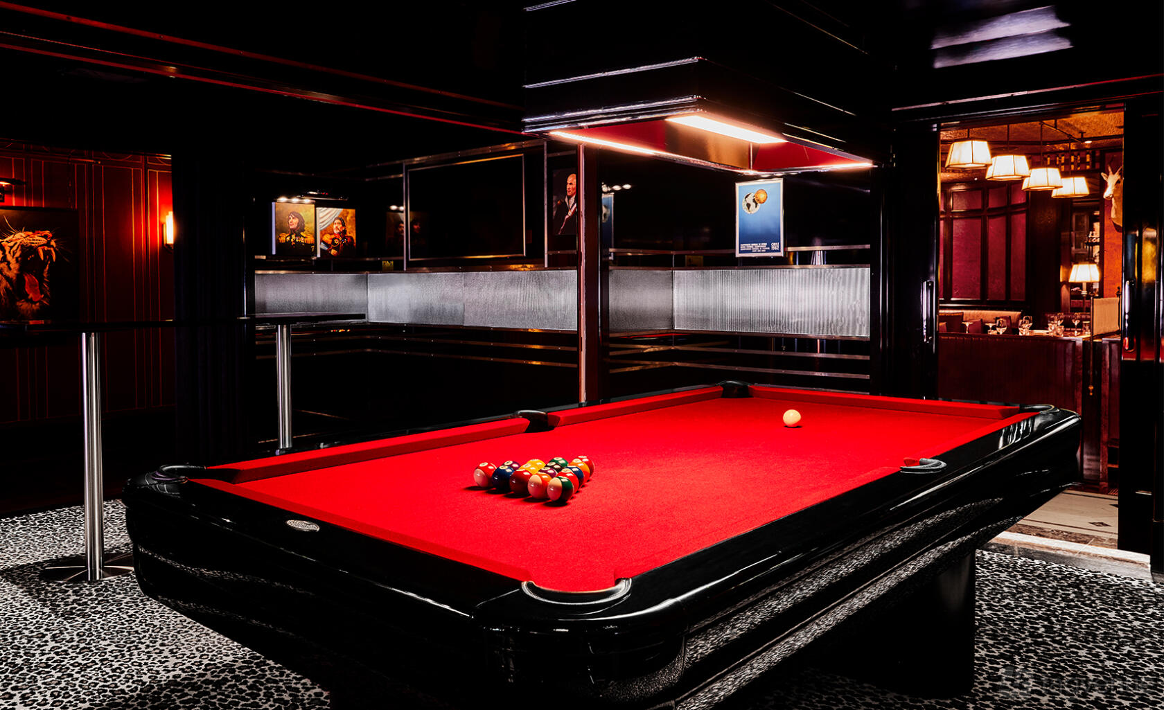 An event space with a red pool table, mirrored walls, and leopard print carpet at Brigadiers.