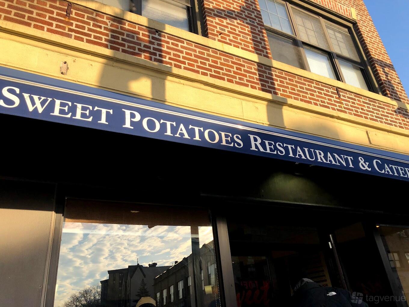 A restaurant storefront with a blue awning and brick exterior at Sweet Potatoes Grande.
