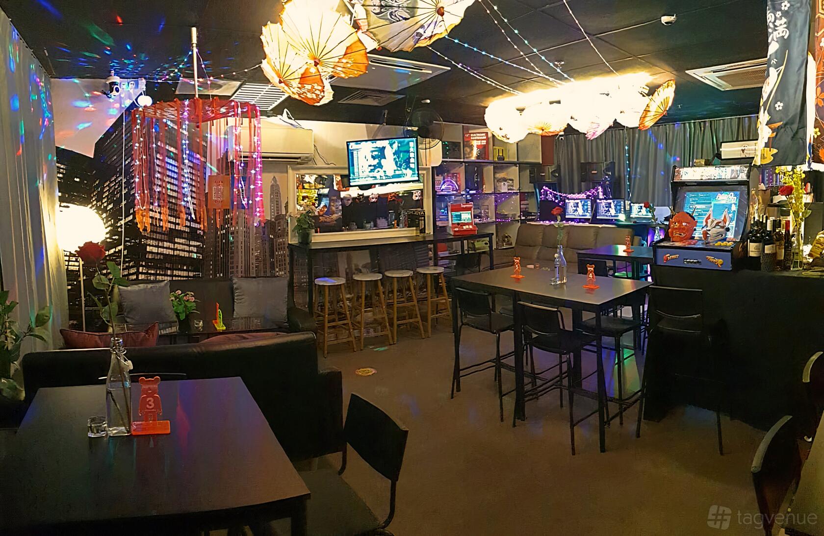 An event venue with arcade games, bar seating, and hanging decorative umbrellas at Ethos Bitro.