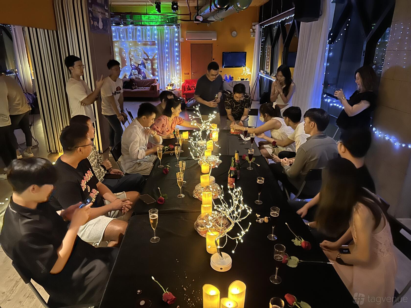 An event space in a dance studio with string lights, candles, and a long table set for a gathering at Dancing with Friends Singapore.