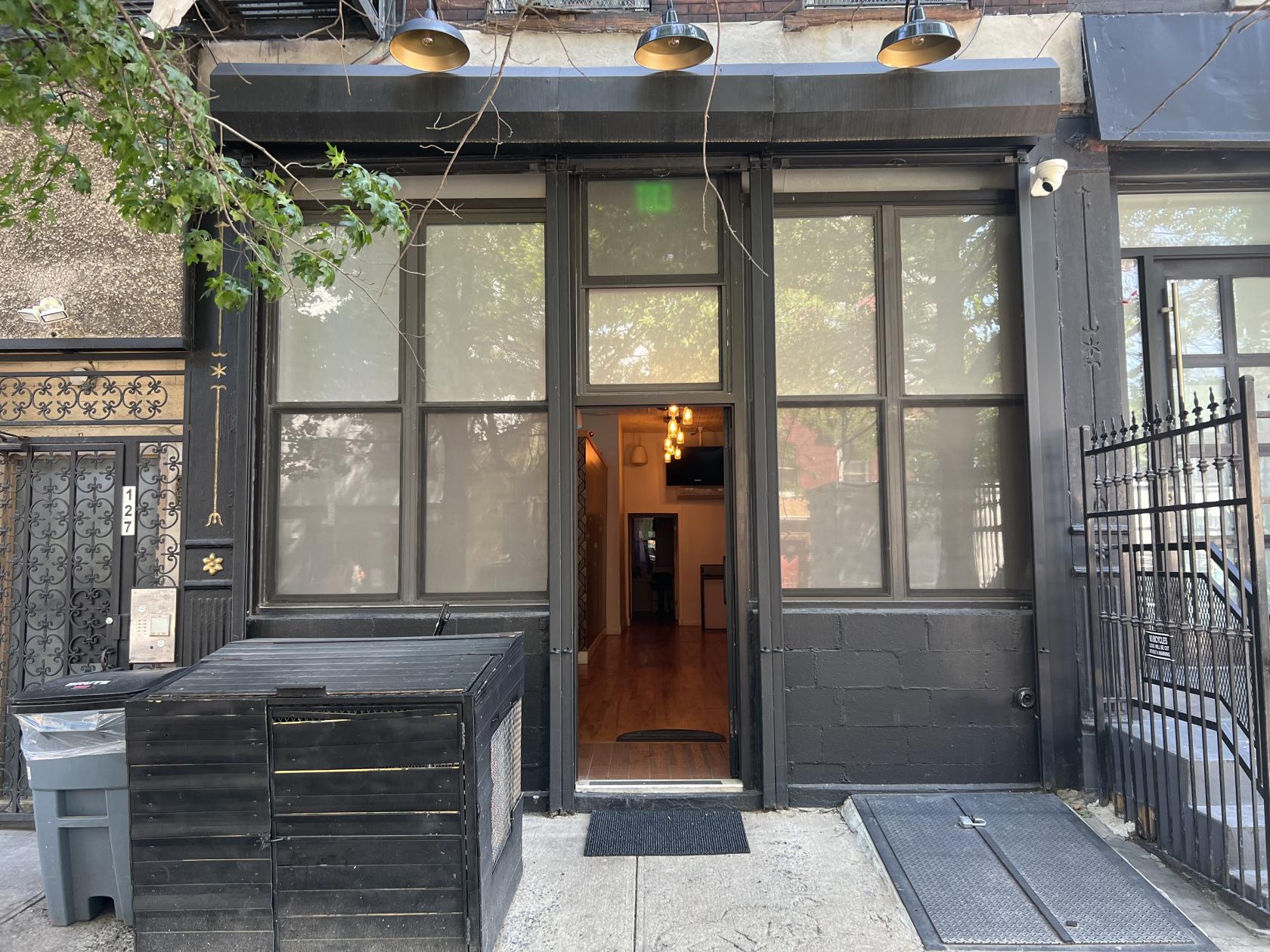 A versatile event space with tall frosted windows, black trim, and an open doorway at H I D D E N