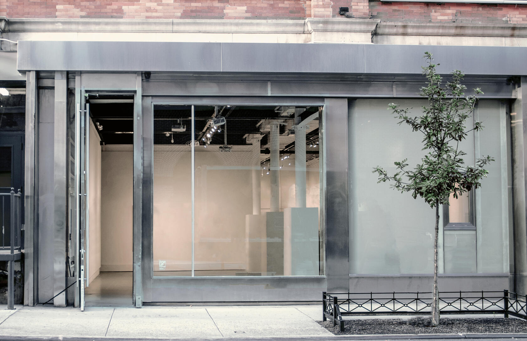 A versatile event space with floor-to-ceiling front windows, glass doors, and minimalist exterior at White Space Chelsea.