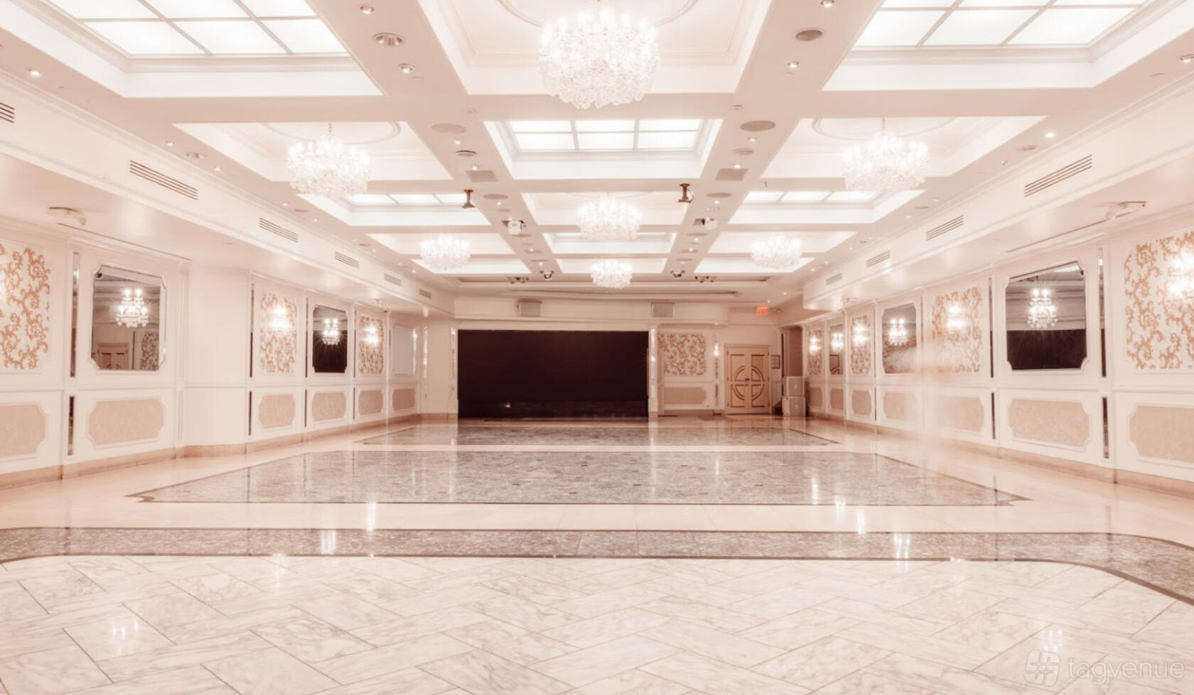 A banqueting hall with marble flooring, chandeliers, and decorative wall panels at Da Mikelle Palazzo.