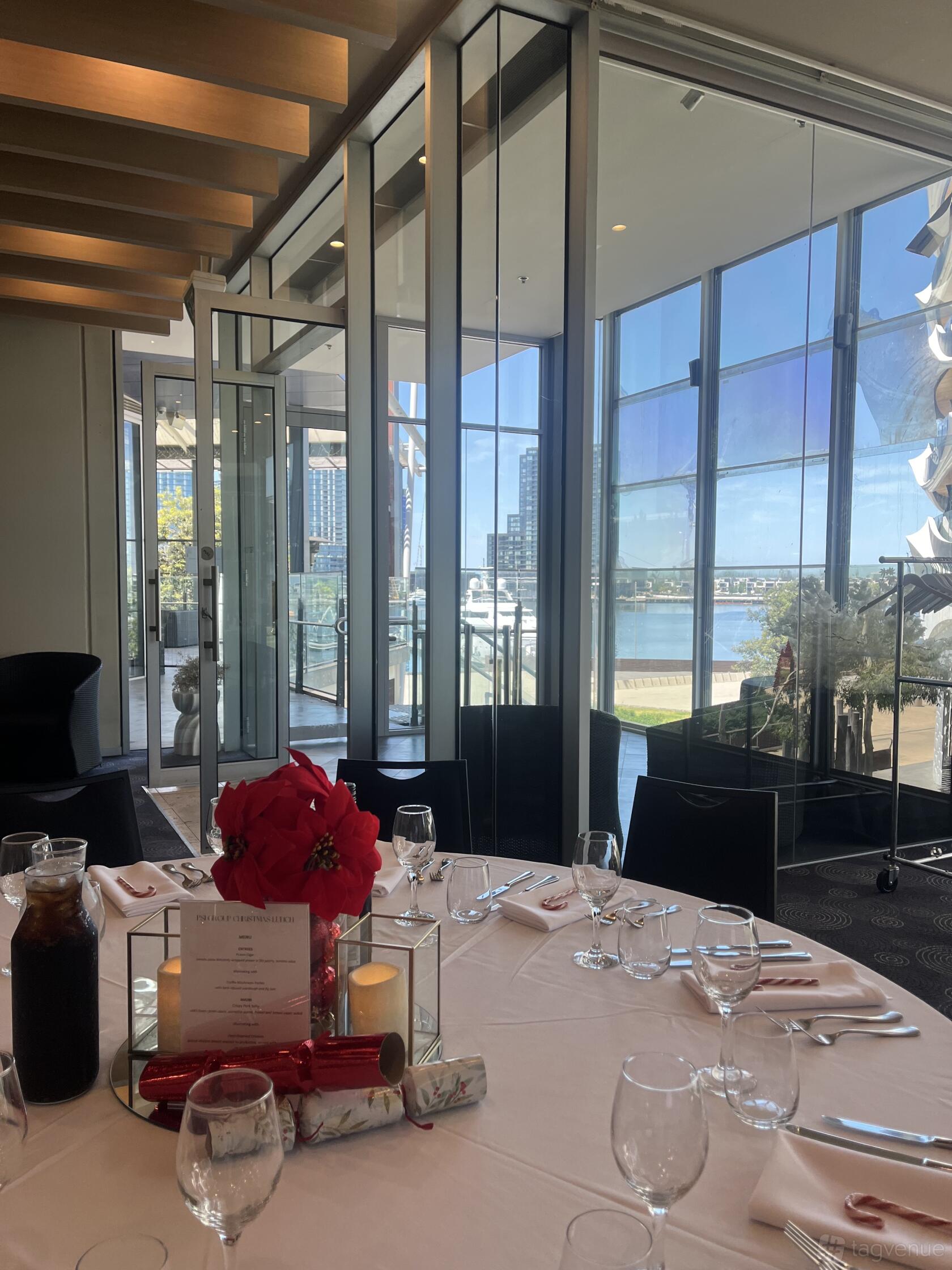 An event venue with floor-to-ceiling glass windows and waterfront views at The Promenade Docklands.