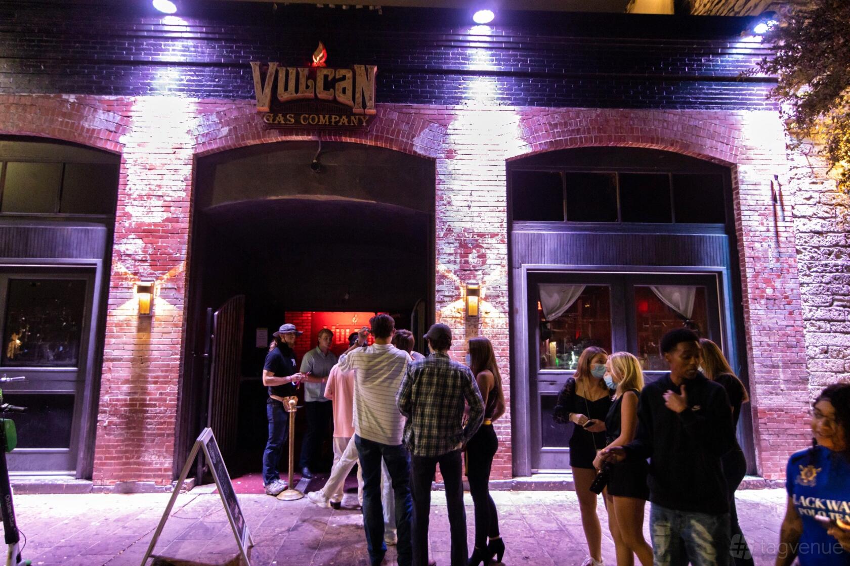An event venue with a brick facade, arched windows, and neon signage at Vulcan Gas Company.