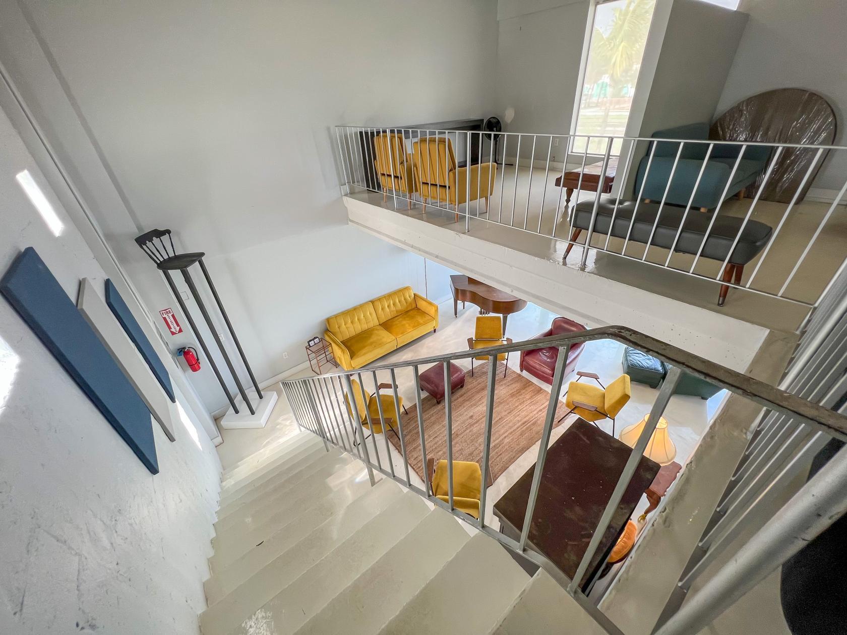 An event space with a split-level layout, colorful seating, and mid-century furnishings at Miami Ironside House of Games.