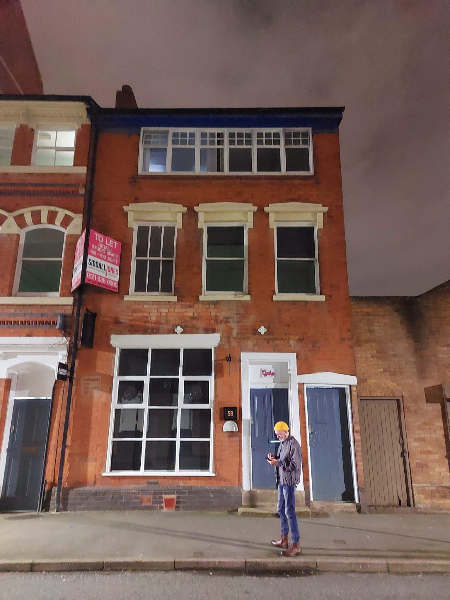A historic building with red brick facade, tall sash windows, and a black door at Gulp.