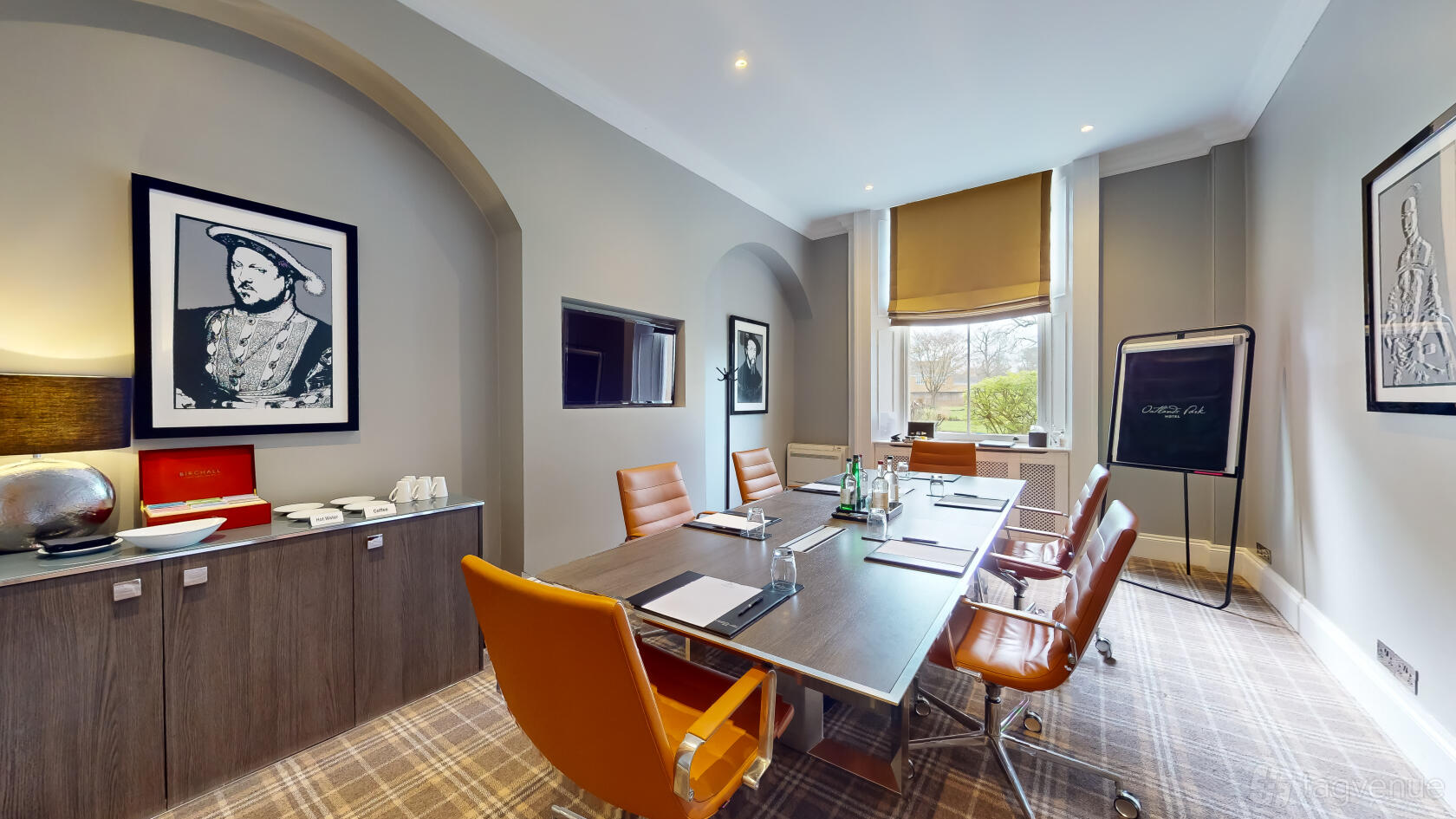 A conference room with leather chairs, a long table set with notepads and water, and large windows at Oatlands Park Hotel.
