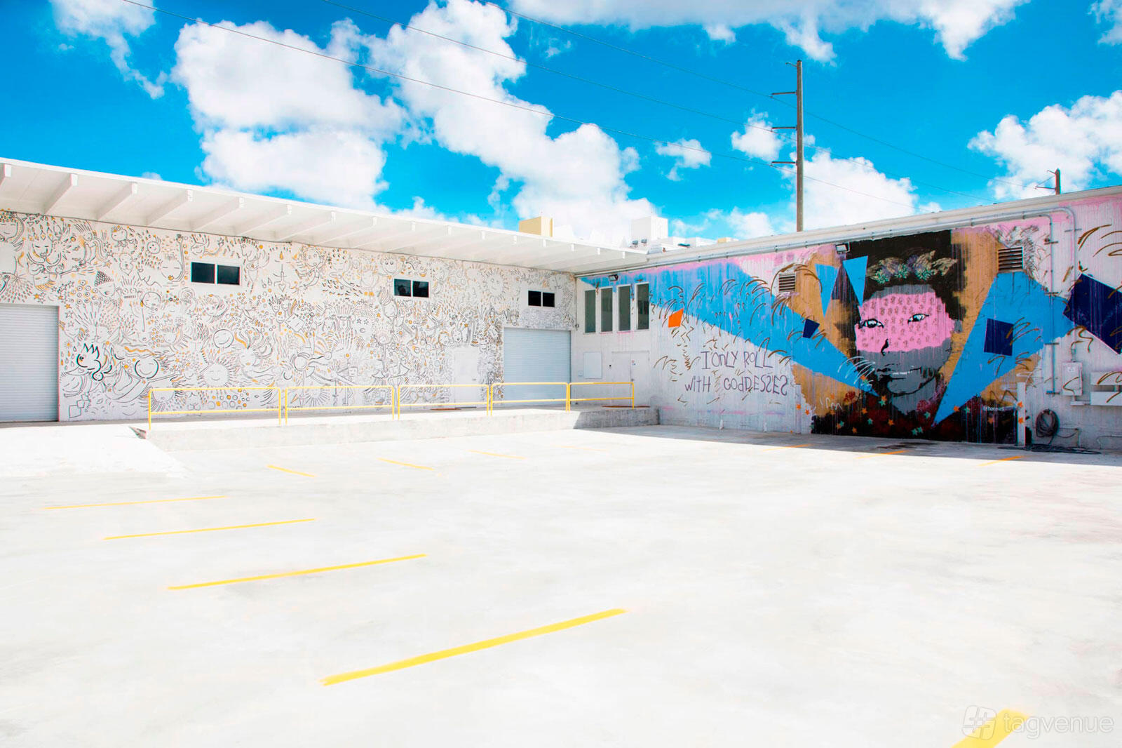 A film and photo studio with a large outdoor lot, white mural walls, and colorful graffiti at WOW Photo Studios Miami.