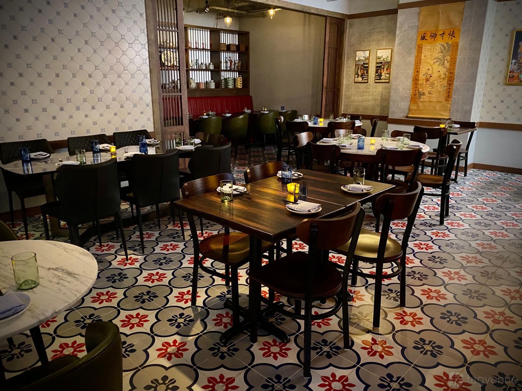 A restaurant dining room with wooden tables, patterned tile floors, and wall art at Yao Atlanta.