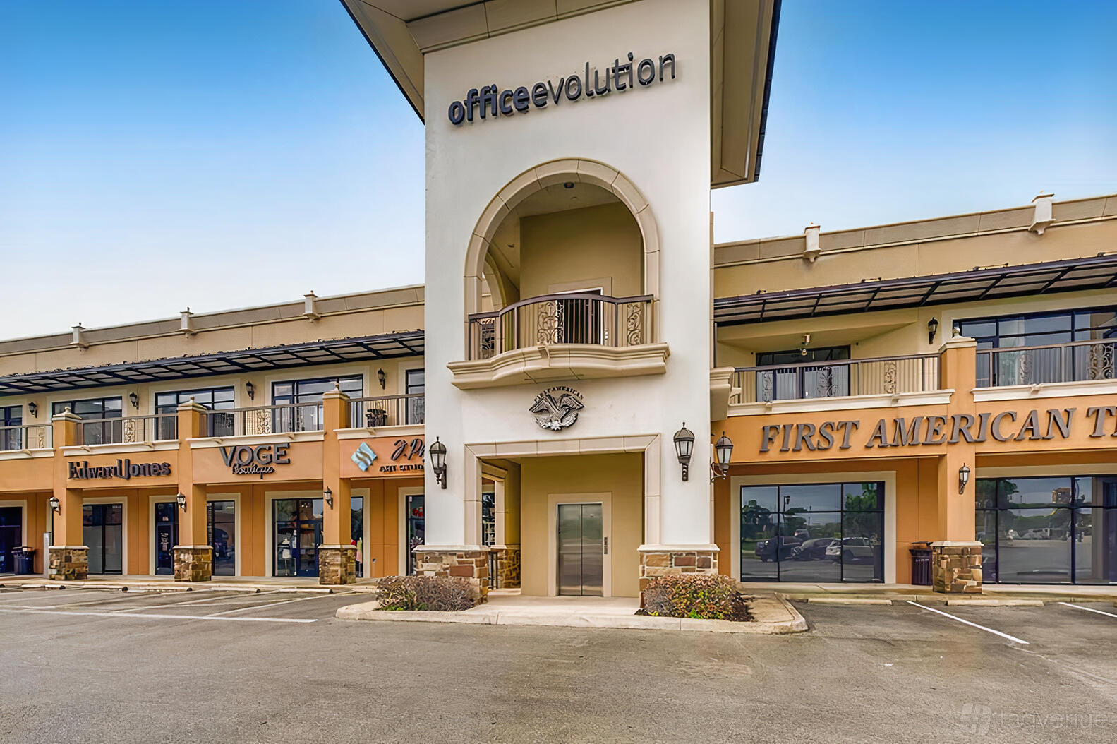 A coworking space with an arched entrance, stone pillars, and balcony at Office Evolution San Antonio.