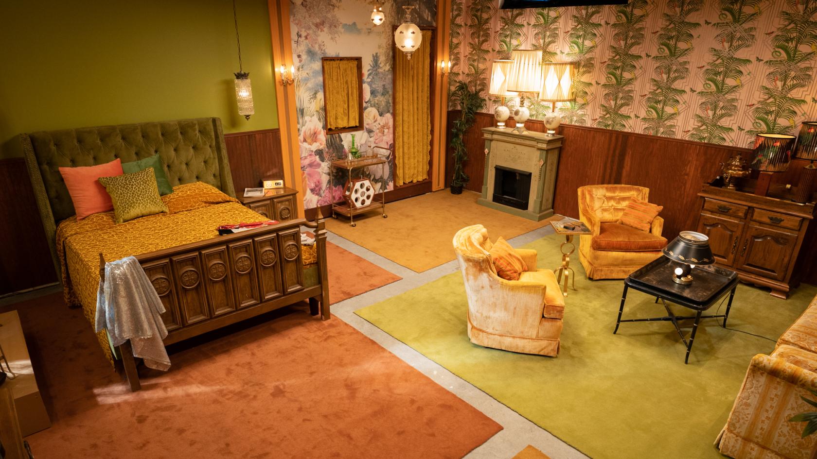 A photo studio with retro wallpaper, vintage furniture, and warm lighting in The Pineapple Room at We Are Here.